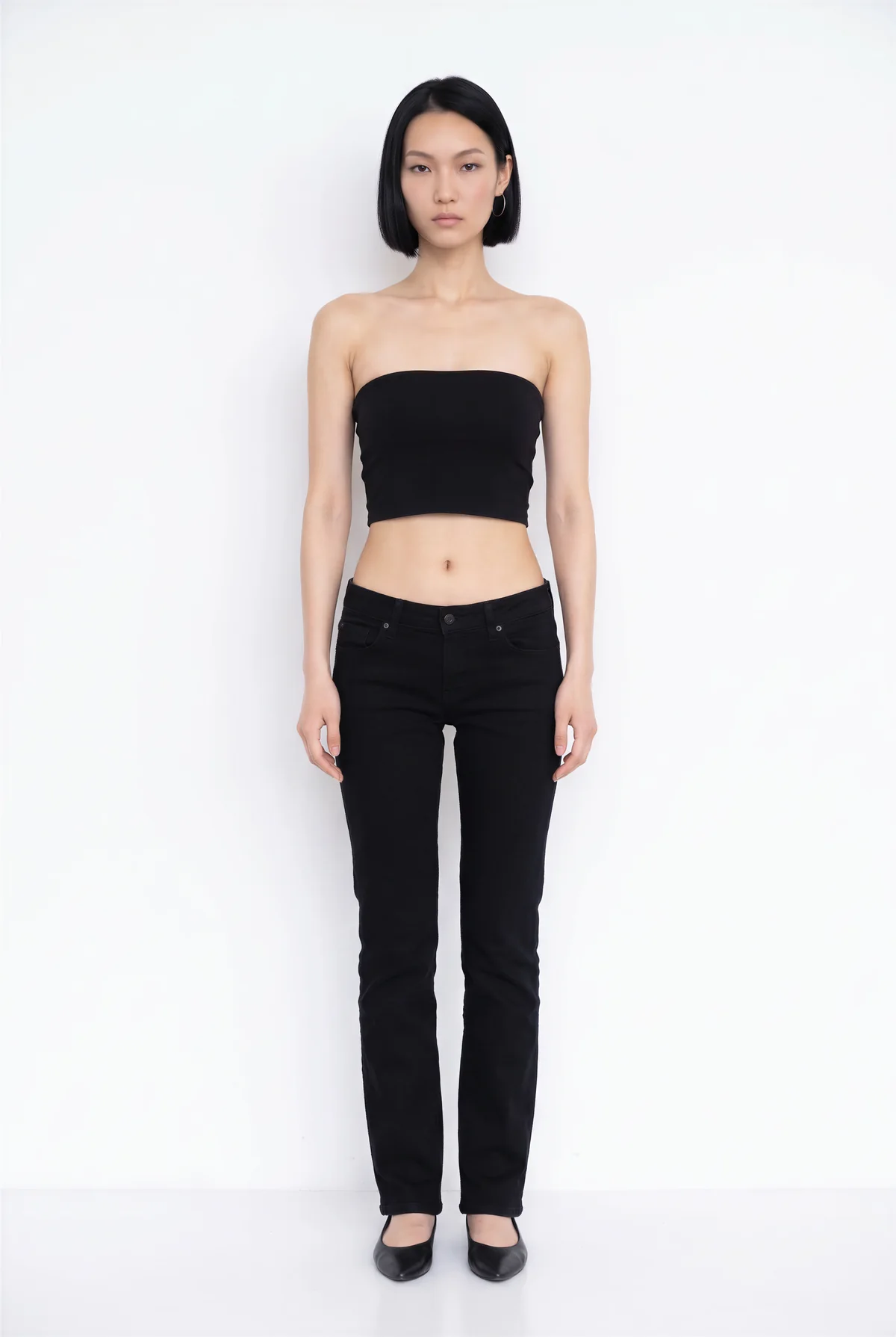 Model image: a woman with a black bob in a black top and trousers on a white background