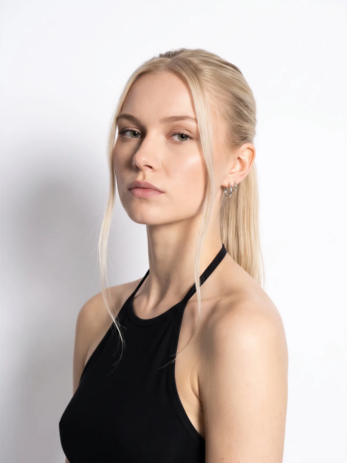 Portrait from Elements: a woman with blonde hair in a ponytail wearing a black halter top