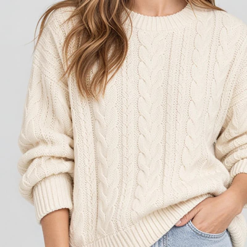 The same close up upscaled 2×: crisp cable knit stitches and ribbed cuffs