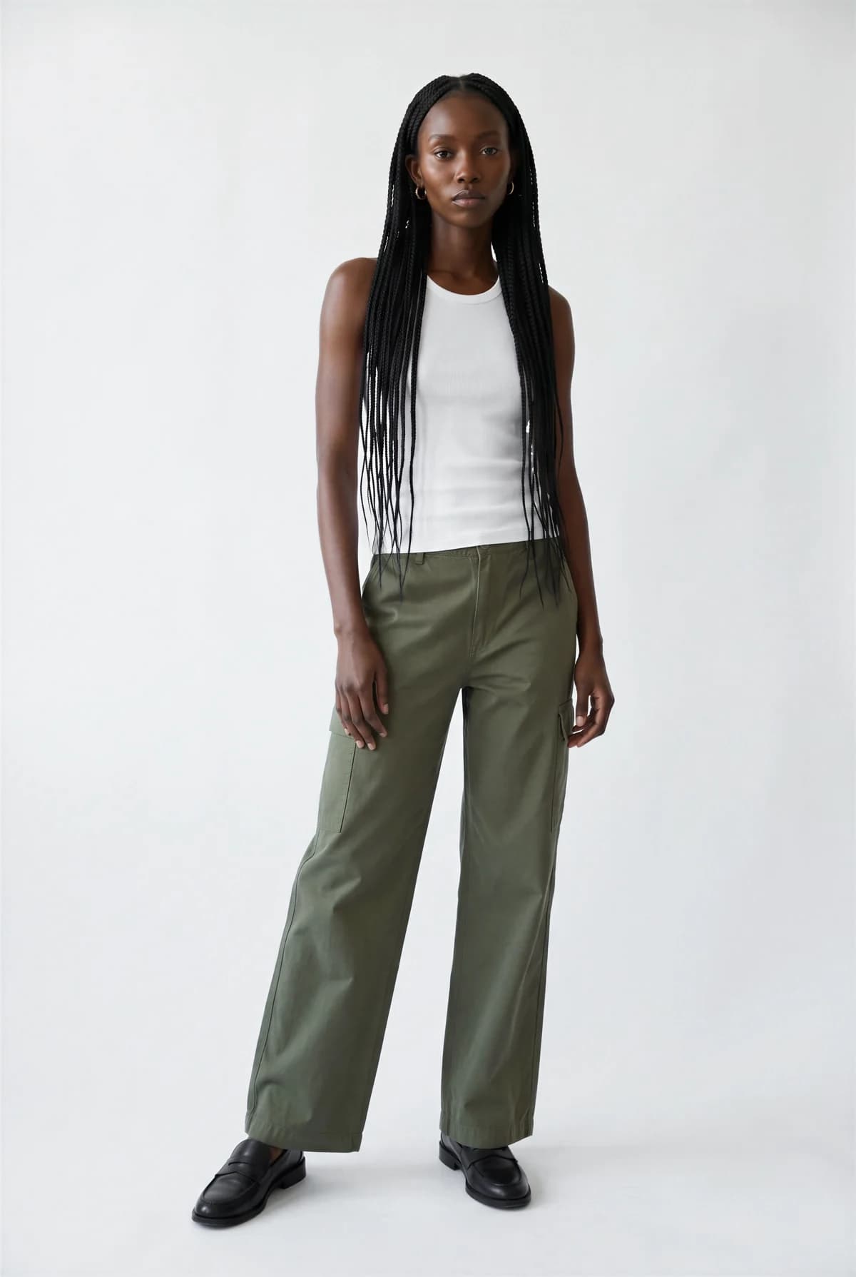 The model chosen from Elements: a Black woman with long braids in a white tank top and olive cargo trousers