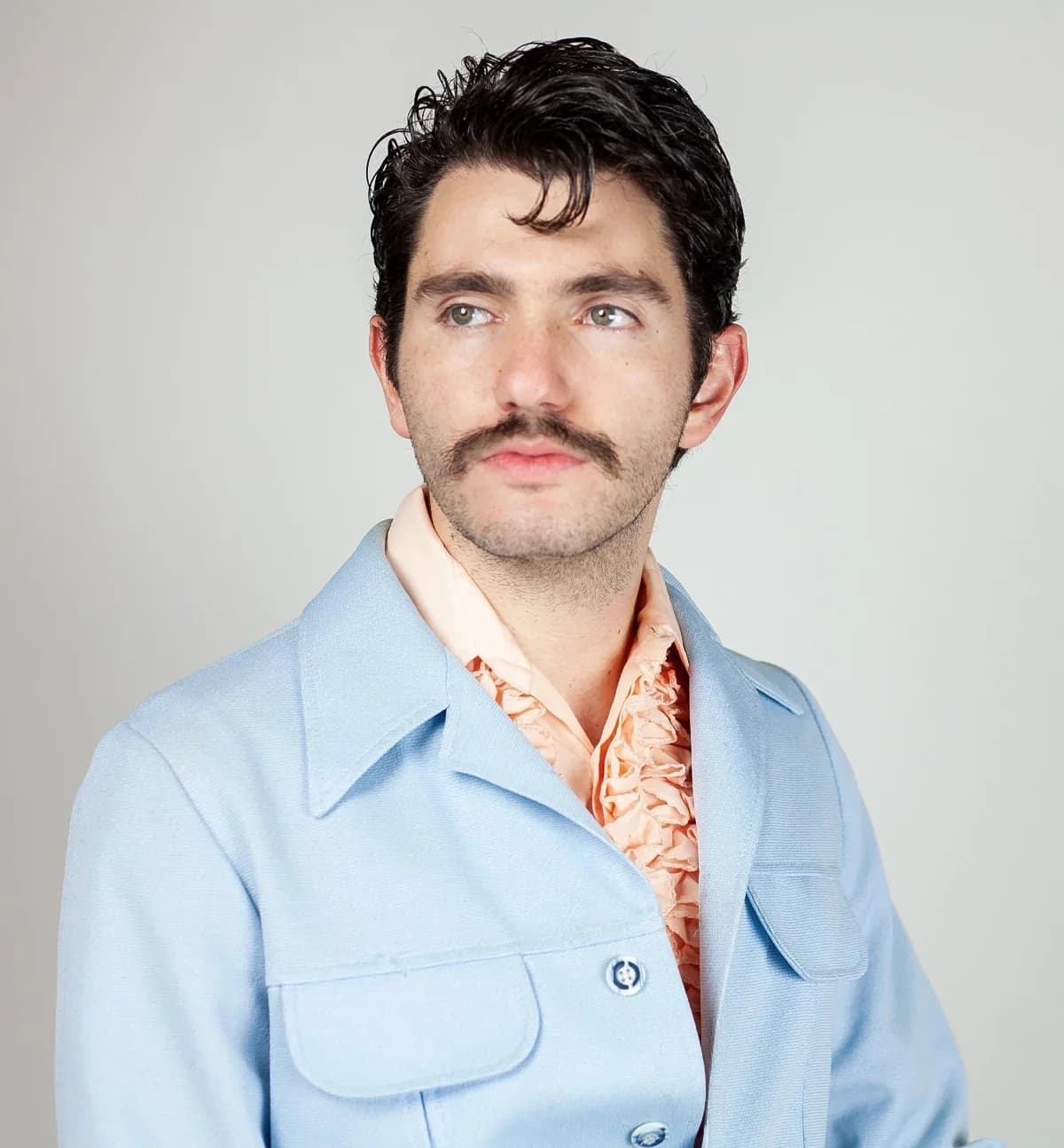 The reference photo: a studio portrait of a man in a light blue jacket and orange ruffled shirt