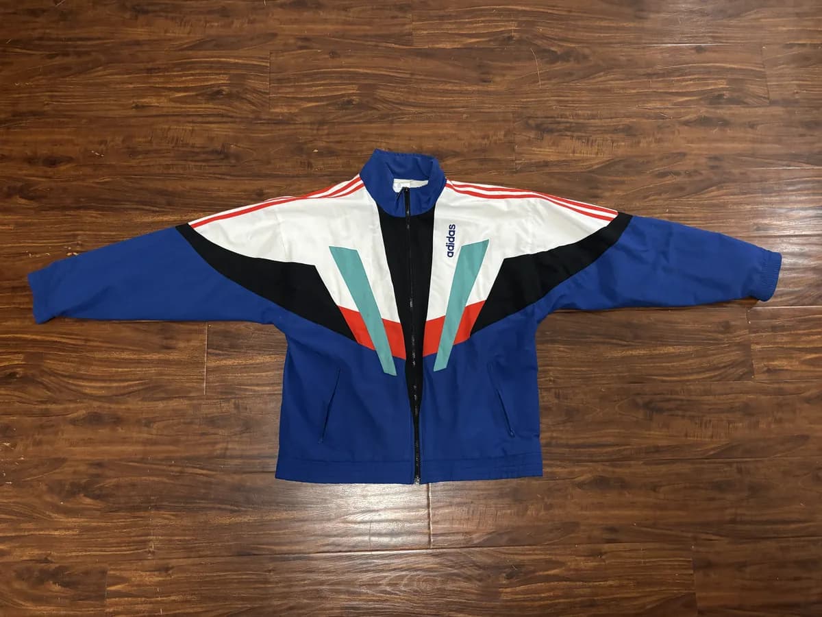 The jacket laid flat on a wooden floor, photographed from above