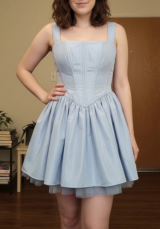 A woman wearing a light blue corset mini dress at home